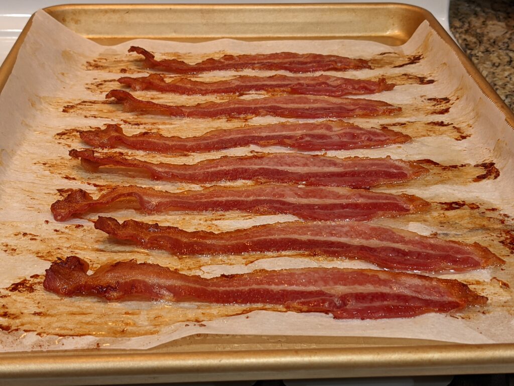 Cooked crispy bacon on a baking sheet.