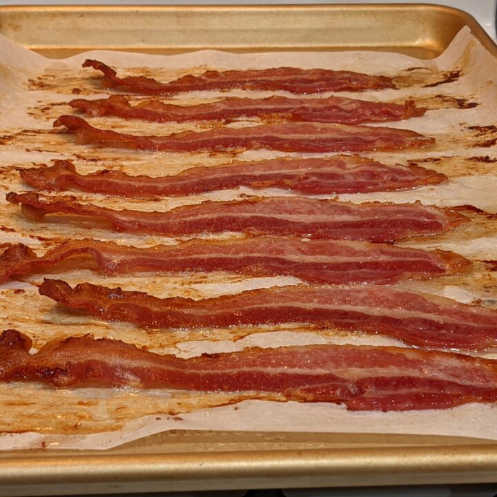Cooked crispy bacon on a baking sheet.