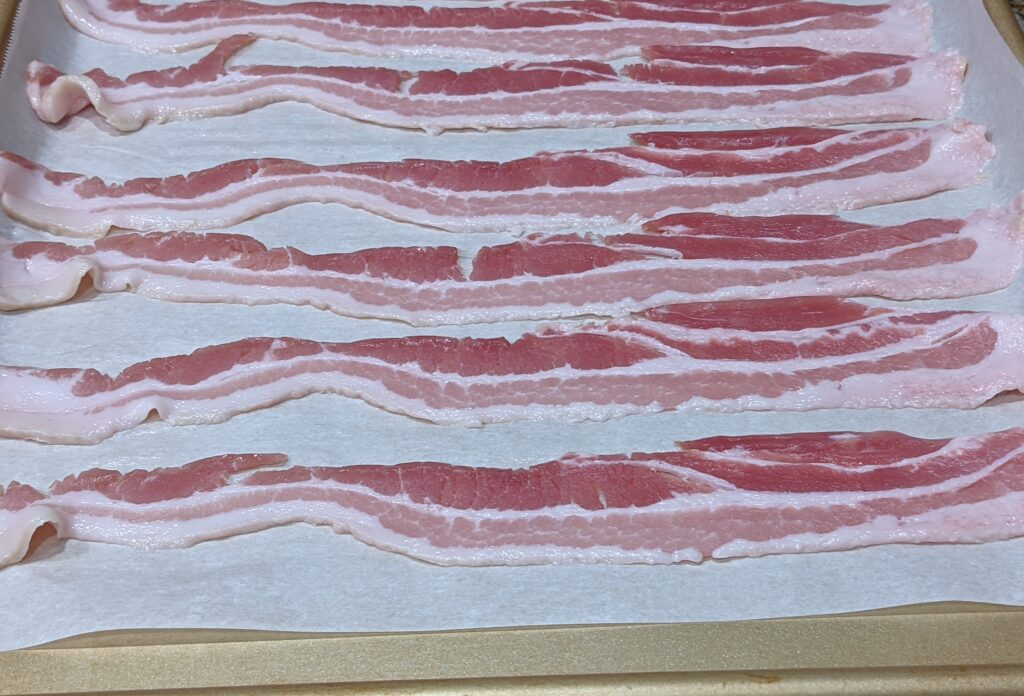 Uncooked Bacon on Baking Sheet